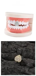 Detail of silver and gold teardrop tooth grillz with baguette and round cut zircons