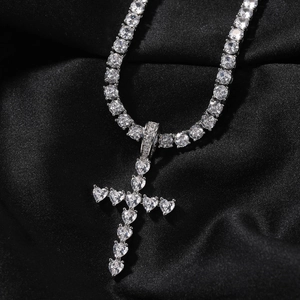 Détail du pendentif croix en zircon cœur et chaîne tennis sur un fond de soie noire
