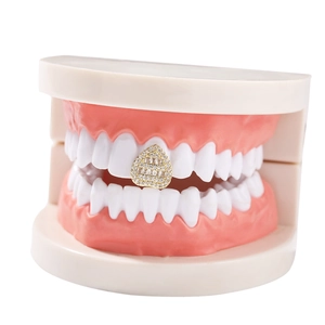 Macro shot of gold hip hop grillz with rectangular and round pavé-set zircons on teeth
