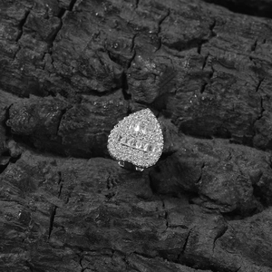 Macro shot of silver heart tooth cap with pave-set round and baguette-cut zircons