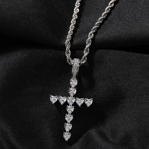 Détail du pendentif croix en cœurs de zircone cubique sur une chaîne corde argentée