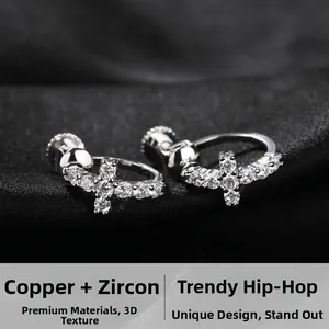 Gros plan de boucles d'oreilles croix argentées avec zircon 5A sur soie noire