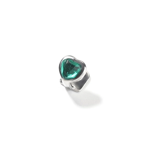 Close-up of hip-hop style silver dental grillz with a sparkling green heart-shaped gem