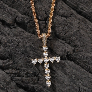 Vue détaillée du pendentif croix en zircons en forme de cœur sur un fond noir texturé
