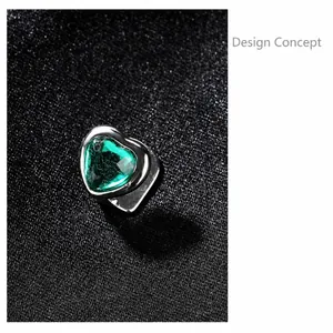 Macro shot of silver hip-hop accessory with a detailed green heart-shaped gemstone