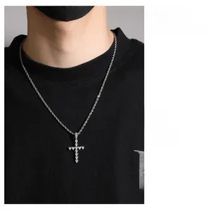 Gros plan du pendentif croix en zircon cœur argenté sur une chaîne de corde torsadée