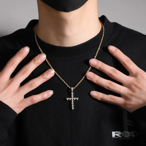 Détail du pendentif croix en zircon en forme de cœur sur une chaîne torsadée dorée