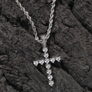 Gros plan du pendentif croix en cœurs de zircone argentée sur chaîne torsadée