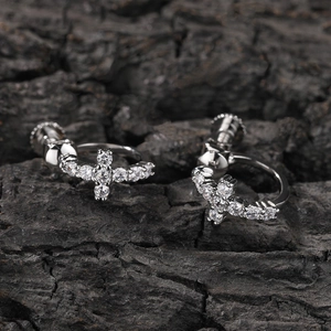 Gros plan de boucles d'oreilles croix en argent avec zircons et fermoirs à vis