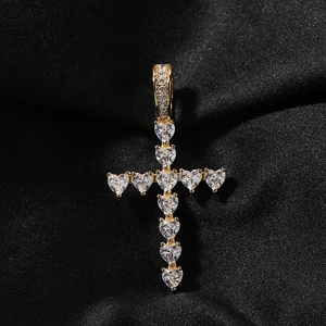 Détail d'un pendentif croix en zircon en forme de cœur sur un fond de soie noire mate
