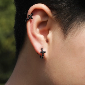 Détail de la boucle d'oreille croix noire et du ear cuff sertis de zircons noirs brillants