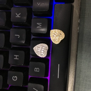 Macro detail of heart-shaped tooth grillz with T-square and round cubic zirconia stones