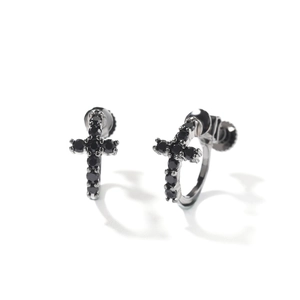 Détail de boucles d'oreilles croix argentées avec pierres noires et fermoir à vis