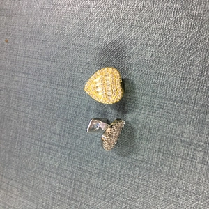 Detail view of heart-shaped tooth grillz or studs with sparkling pavé zircon stones
