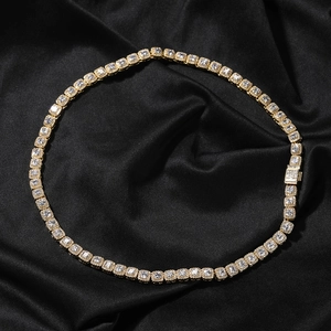 Macro detail of gold tennis chain with square cut cubic zirconia on black silk