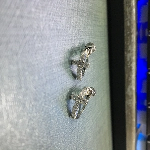 Détail de boucles d'oreilles créoles croix en argent serties de zircons 5A brillants