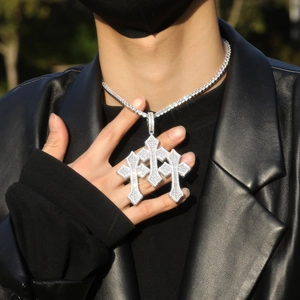 Close-up of hip hop silver triple cross pendant with baguette zircons on tennis chain
