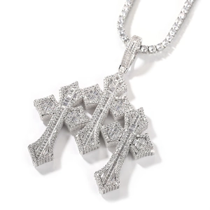 Macro shot of silver triple layered cross pendant with square baguette zircon stones
