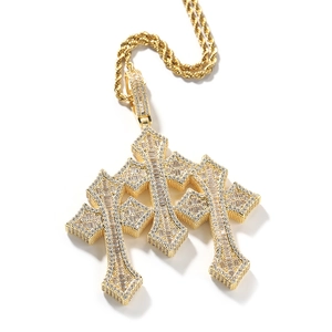 Macro detail of gold cross pendant with cubic zirconia inlay on twist rope chain