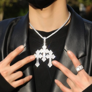 Detailed view of iced out cross pendant and tennis chain set with white zircons
