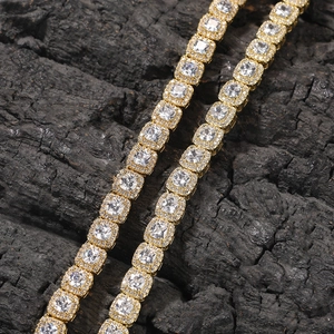 Macro detail of 7mm golden tennis chain necklace featuring zircon stones on black carbon