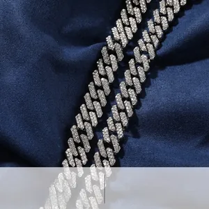 Close-up of sparkling rhinestone pavé cuban link necklace on textured blue background