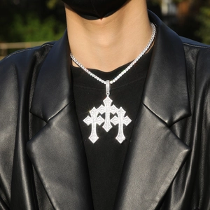 Close-up of a men's gothic cross pendant with white zircon on a tennis chain