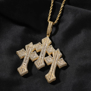 Macro shot of gold gothic triple cross pendant with baguette cubic zirconia on black silk
