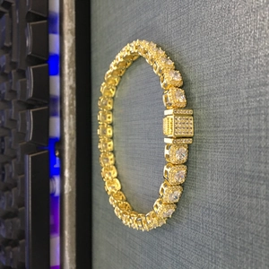 Macro view of 7mm golden hip hop chain with square cubic zirconia and box clasp