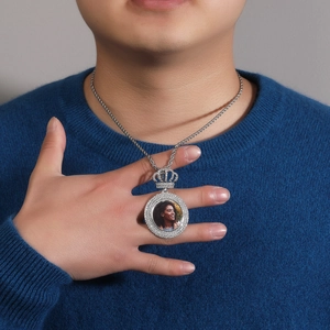 Gros plan du pendentif médaillon couronne en diamants avec chaîne torsadée sur un modèle
