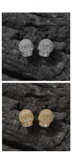Détail de boucles d'oreilles crâne hip hop avec zircons en finitions or et argent