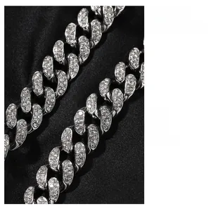 Macro detail of 12mm silver Cuban link chain with paved rhinestones on black silk