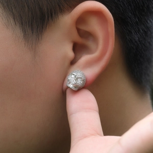 Vue détaillée du clou d'oreille crâne en argent avec zircons sertis sur l'oreille d'un homme