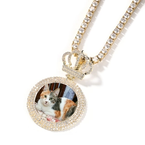 Détails rapprochés d'un pendentif photo couronne doré orné de cristaux brillants
