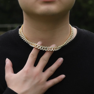 Close-up of men's gold plated Cuban link necklace with micro-pave diamond accents