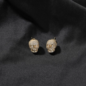 Vue détaillée des boucles d'oreilles crâne dorées avec oxydes de zirconium sertis