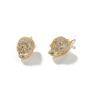Gros plan de boucles d'oreilles tête de mort hip-hop avec zircons sertis en micro-pavé