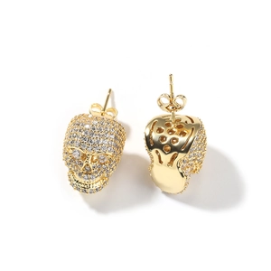 Vue détaillée des boucles d'oreilles crâne en or avec zircons et dos en nid d'abeille