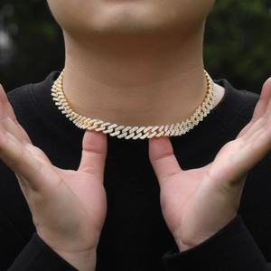 Close-up of a gold-toned Cuban link chain encrusted with brilliant white crystals for men