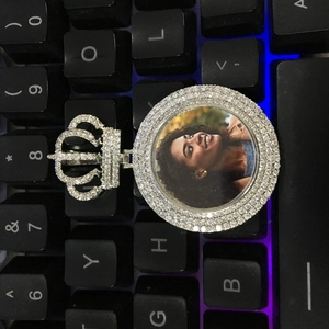 Gros plan d'un pendentif photo rond avec fermoir couronne en diamant sur un clavier