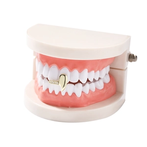 Macro detail of gold hip hop single grillz with iced out zircon stones on white dental model