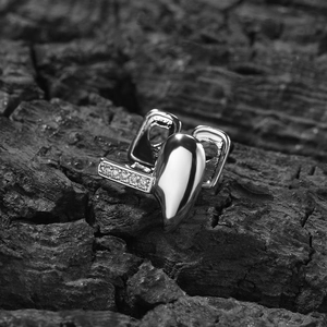 Macro view of silver heart-shaped tooth grillz with inlaid gems on dark textured stone