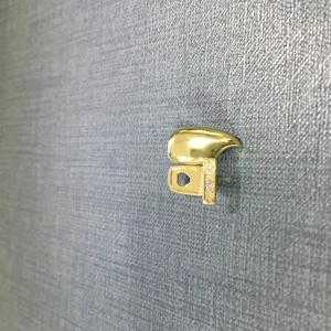 Macro detail of golden hip hop style fang pendant with sparkling zircon inlays