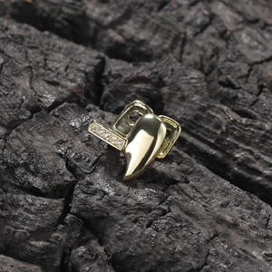 Hip hop gold single tooth grillz with sparkling diamonds on rustic charcoal background