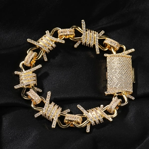 Macro detail of gold barbed wire link bracelet with sparkling paved rhinestones