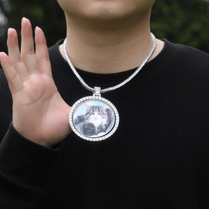 Macro detail of iced out spinning photo pendant necklace with sparkling tennis chain