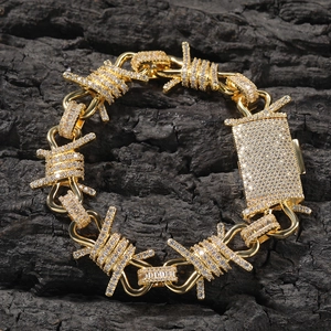 Macro detail of gold-plated hip-hop thorn chain bracelet with sparkling white zircon pavé
