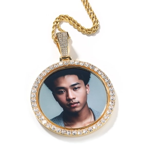 Detailed view of large golden rotary photo pendant with sparkling cubic zirconia rim
