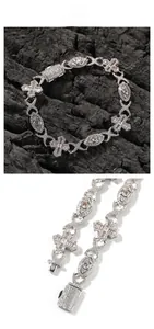 Detailed macro view of hip hop cross and eye link bracelet with white cubic zirconia pavé