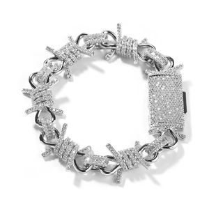 Macro detail of silver barbed wire link necklace with cubic zirconia pave clasp